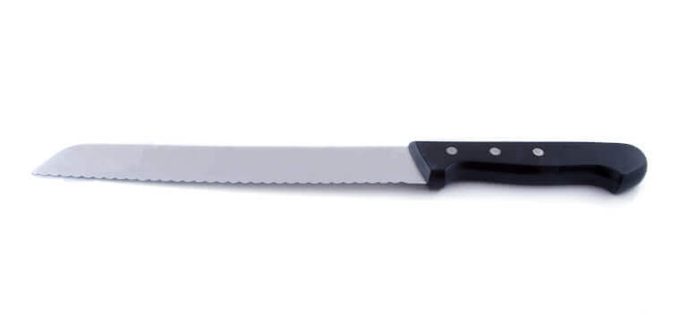 Closeup of a bread knife on white background.