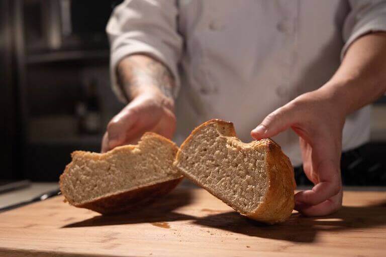 A close-up of a hand-made loaf of bread, cut in half.