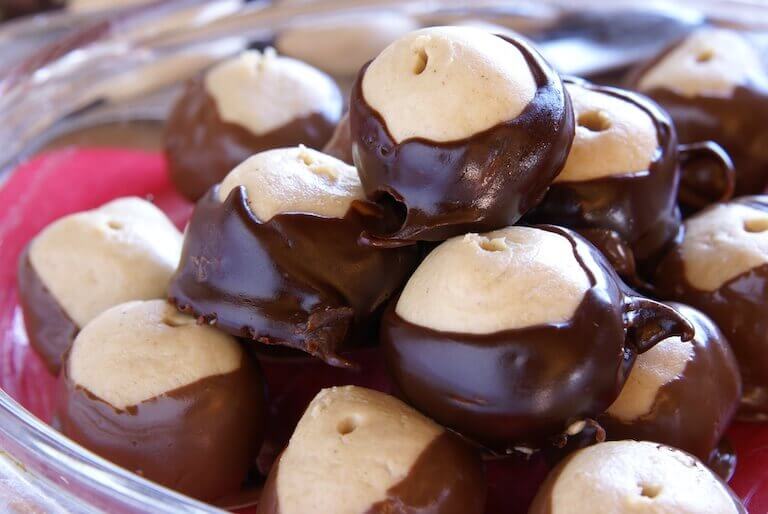 Close up image of buckeye candies in a clear glass bowl.