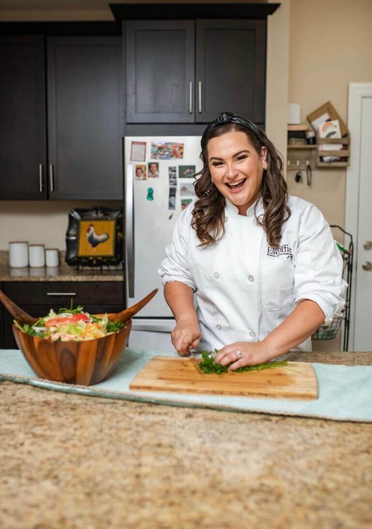 Escoffier student lisa chopping vegetables in her kitchen