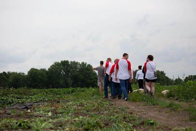 Escoffier students and staff walking along a path at Rustic Roads Farm, experiencing hands-on learning about local food production