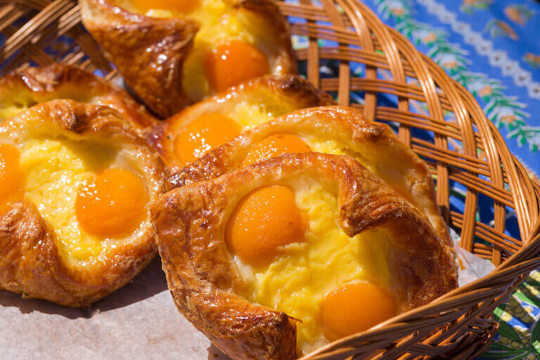 Flaky French oranais pastries with apricots and cream filling, resting in a basket.
