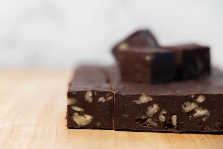 Stacked slices of chocolate fudge with walnuts.