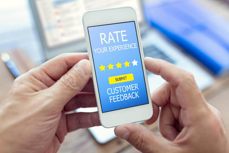 Hands holding a phone with the words rate your experience on the screen