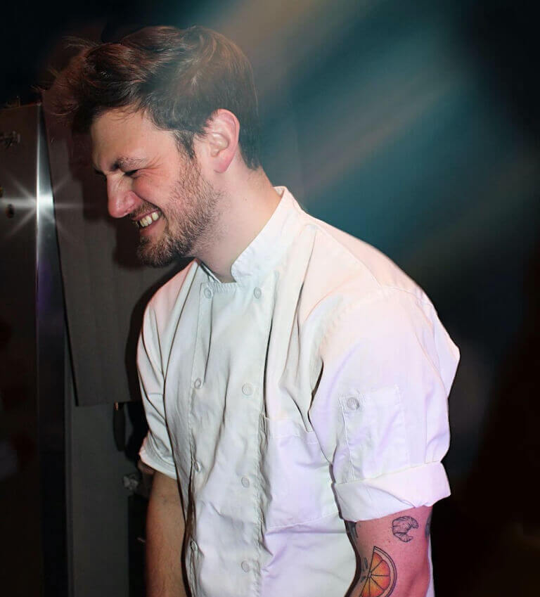 Wes Duckworth sporting culinary attire and grinning from ear to ear.