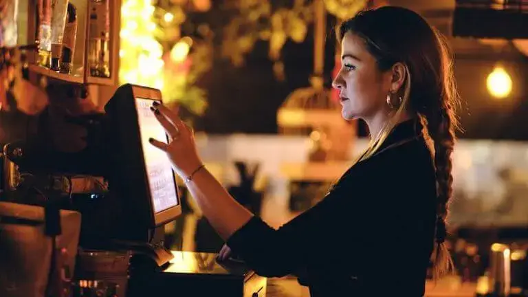 A front of house employee working on a point of sale system.