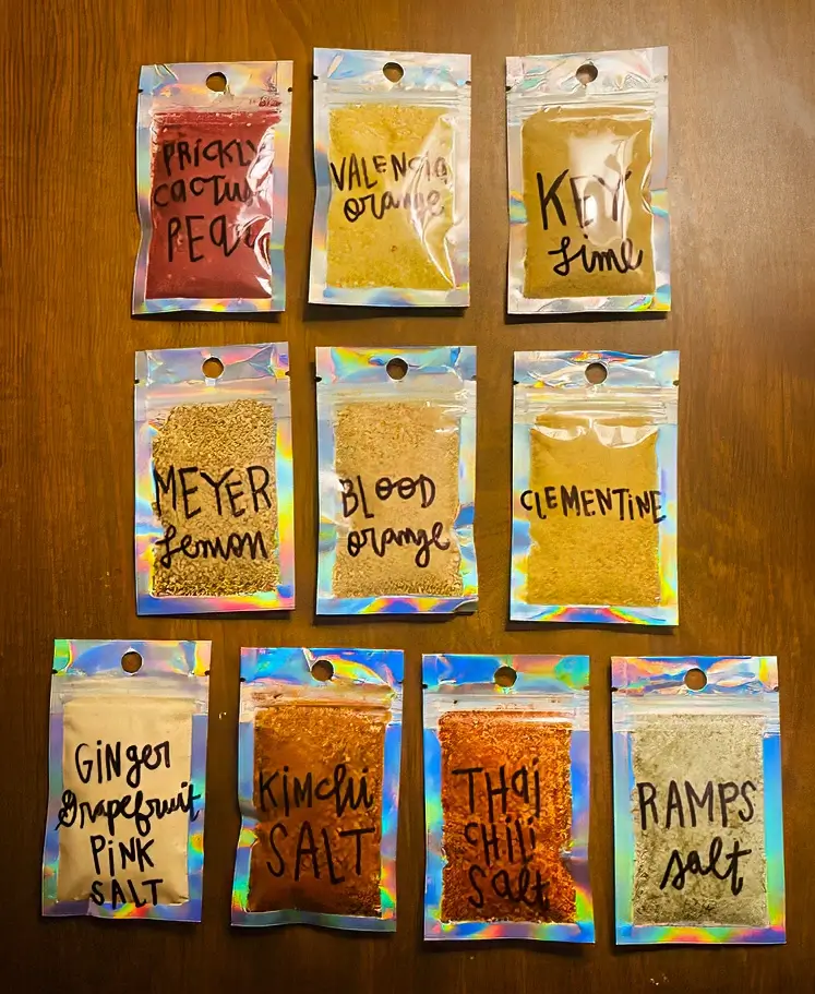 Ten labeled spice packets filled with Bree’s handmade citrus and savory blends, like Valencia orange, kimchi salt, and ramps salt.